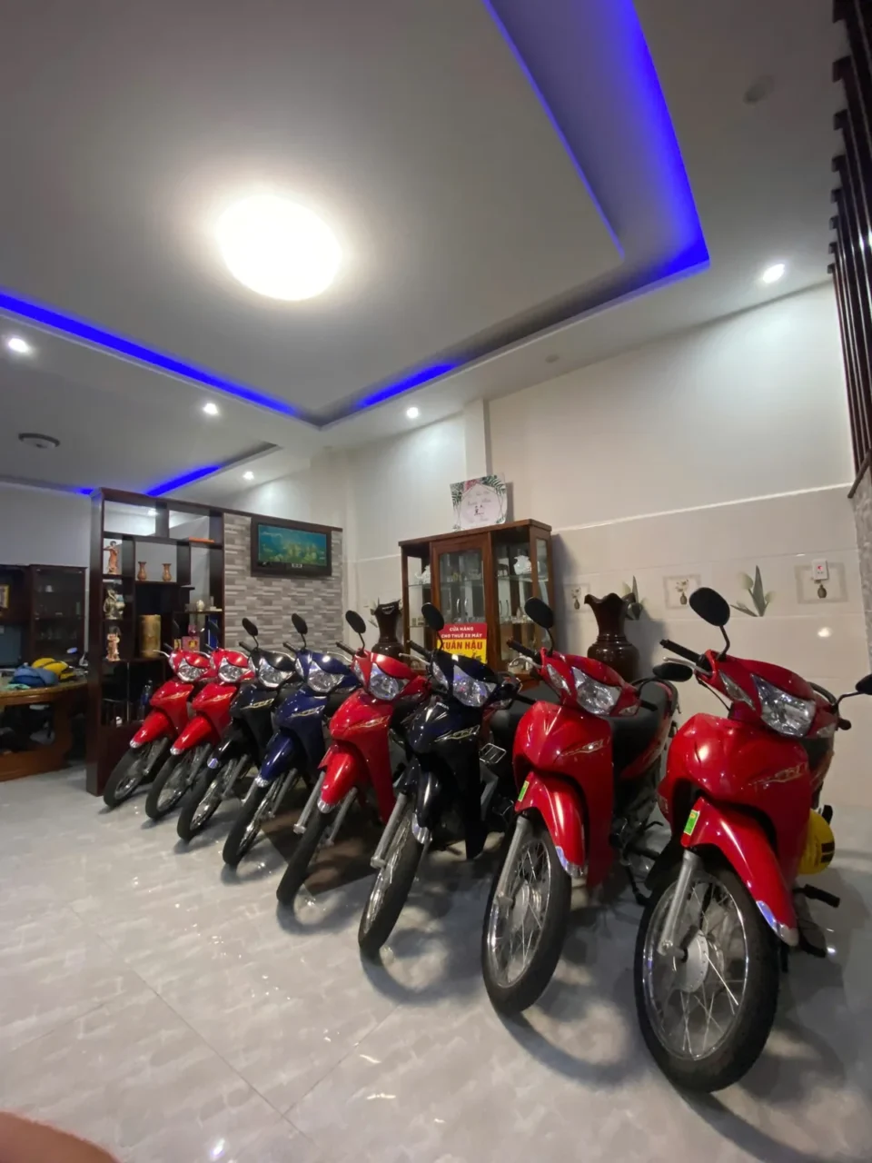 Dàn xe số Honda màu đỏ và xanh đỗ bên trong cửa hàng Xuân Hậu ở Quảng Ngãi